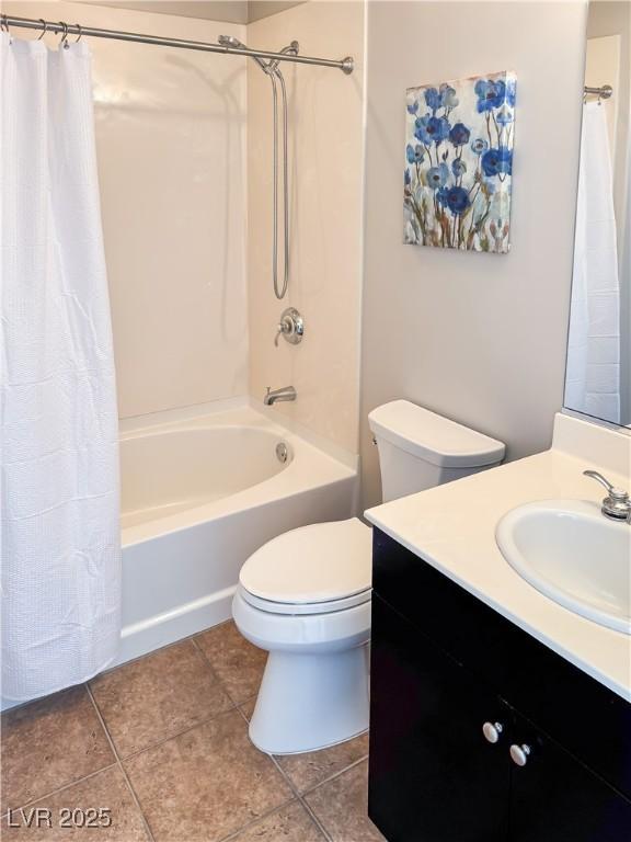 bathroom featuring toilet, tile patterned flooring, shower / bath combo with shower curtain, and vanity