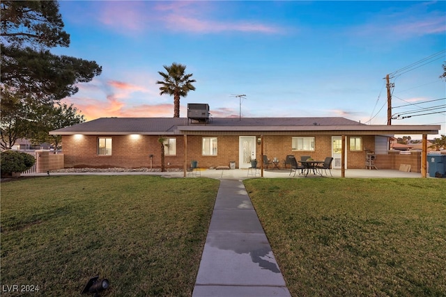 single story home featuring a patio area, a yard, and central AC unit