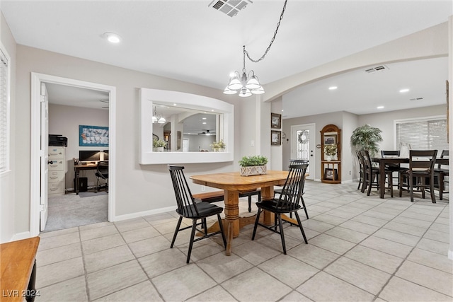 tiled dining space with a notable chandelier