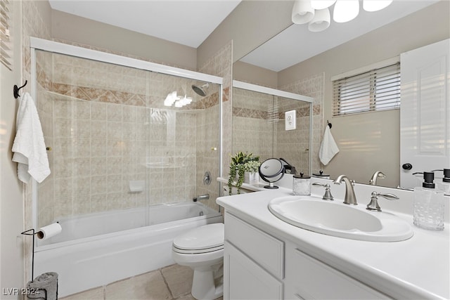 full bathroom featuring tile patterned flooring, vanity, tiled shower / bath combo, and toilet