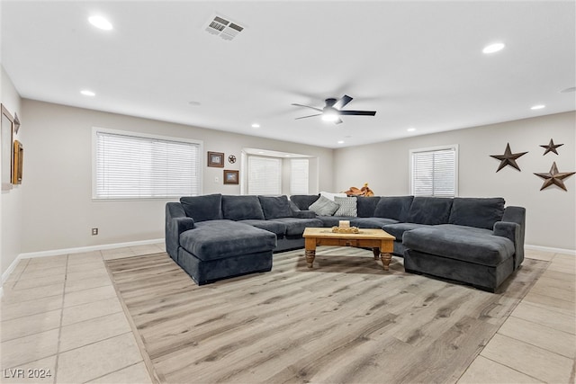 living room featuring light hardwood / wood-style flooring, ceiling fan, and a healthy amount of sunlight