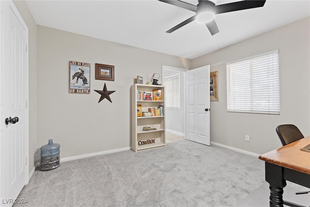 carpeted home office featuring ceiling fan