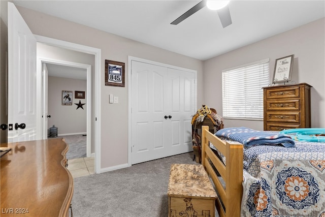 bedroom featuring ceiling fan, light carpet, and a closet