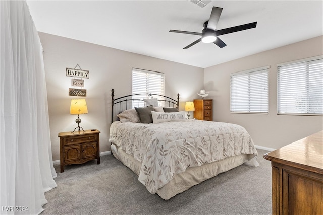 carpeted bedroom featuring multiple windows and ceiling fan