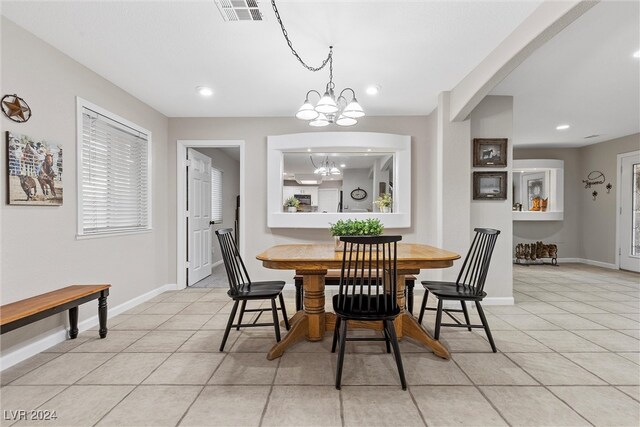 dining area with light tile patterned floors and a notable chandelier