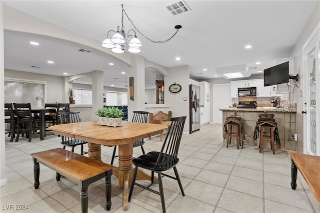 tiled dining area with an inviting chandelier