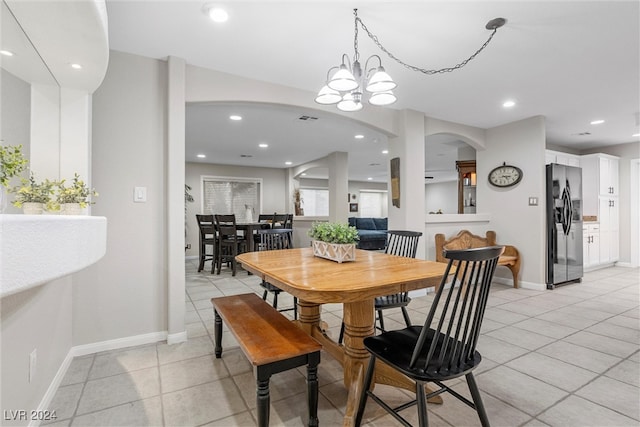 dining space featuring light tile patterned floors and a chandelier