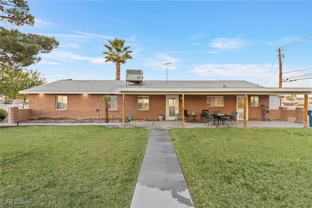 back of property with a lawn, a patio area, and cooling unit