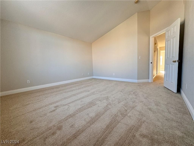 carpeted spare room featuring high vaulted ceiling