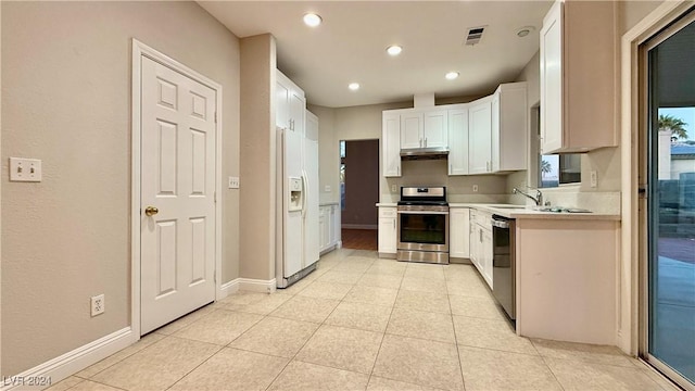 kitchen with white cabinets, sink, light tile patterned floors, and stainless steel appliances