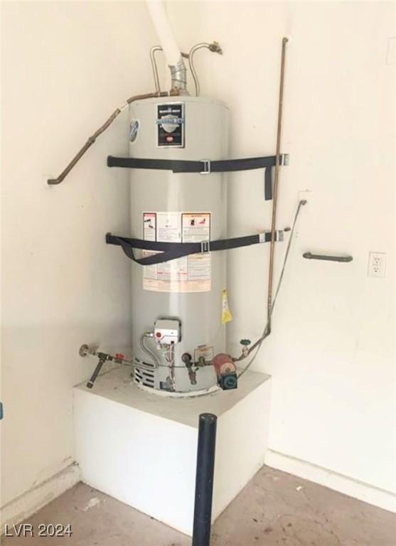 utility room featuring strapped water heater