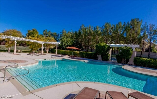 outdoor pool with a patio, fence, and a pergola