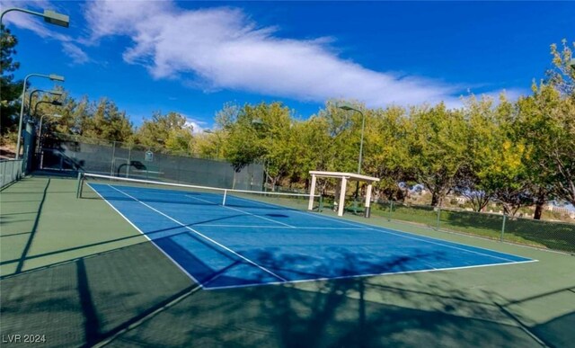 view of tennis court featuring fence