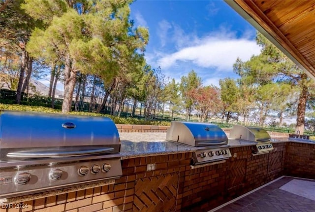 view of patio featuring an outdoor kitchen and a grill