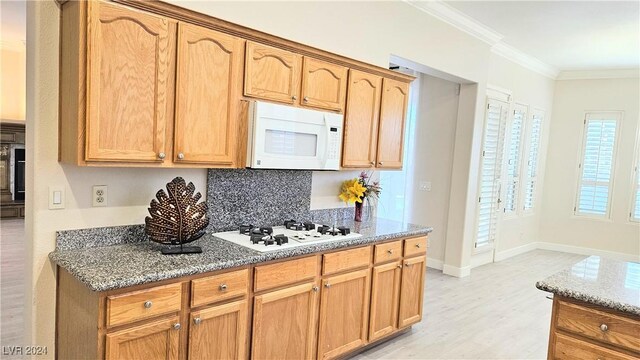 kitchen featuring white appliances, light stone countertops, light wood-style flooring, and crown molding