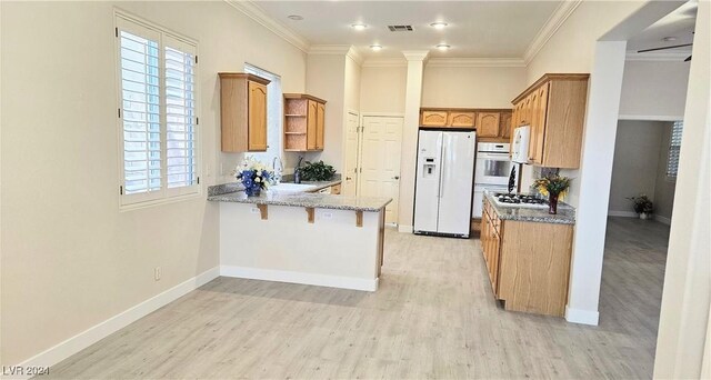 kitchen with white appliances, light wood finished floors, visible vents, ornamental molding, and a peninsula