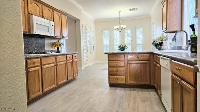 kitchen with brown cabinets, light wood finished floors, visible vents, white appliances, and a peninsula