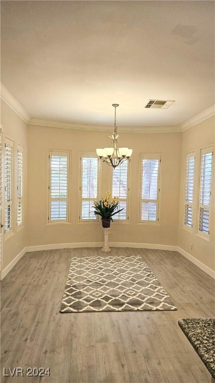 unfurnished dining area with visible vents, crown molding, and wood finished floors