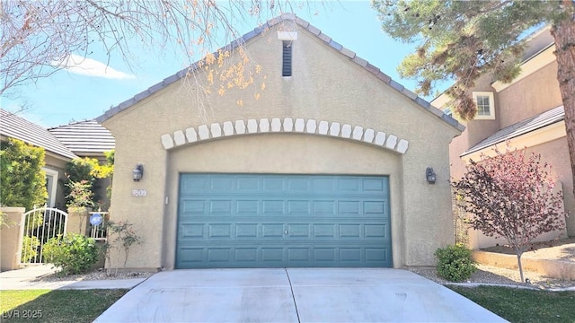 exterior space featuring an outbuilding, a garage, a tile roof, driveway, and stucco siding