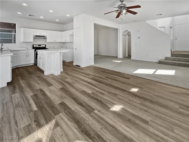 kitchen featuring stainless steel range oven, dark hardwood / wood-style floors, white cabinetry, a kitchen island, and ceiling fan