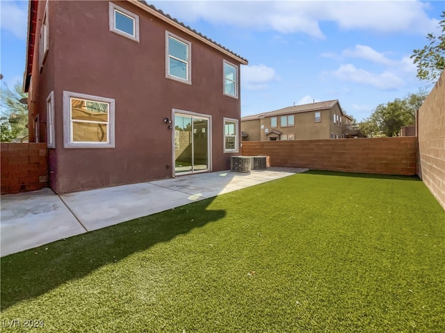 back of property featuring a lawn, cooling unit, and a patio area