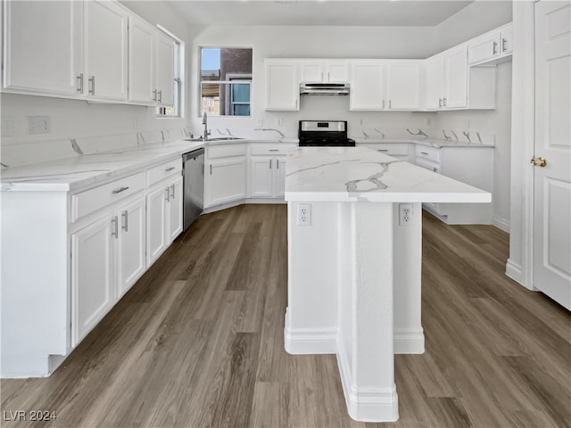 kitchen with hardwood / wood-style flooring, white cabinets, a kitchen island, stainless steel appliances, and light stone countertops