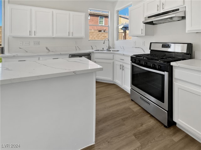 kitchen with light stone counters, sink, white cabinetry, appliances with stainless steel finishes, and light hardwood / wood-style floors