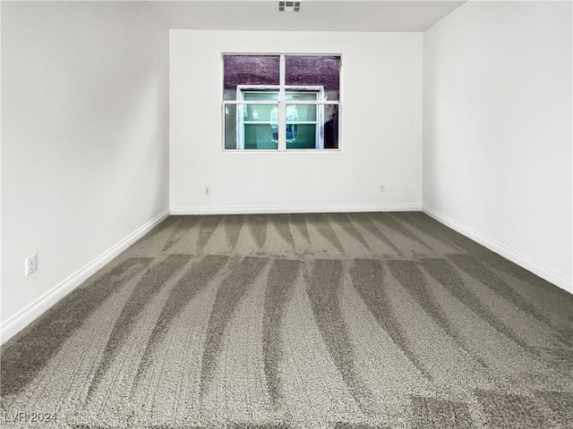 unfurnished room with dark carpet