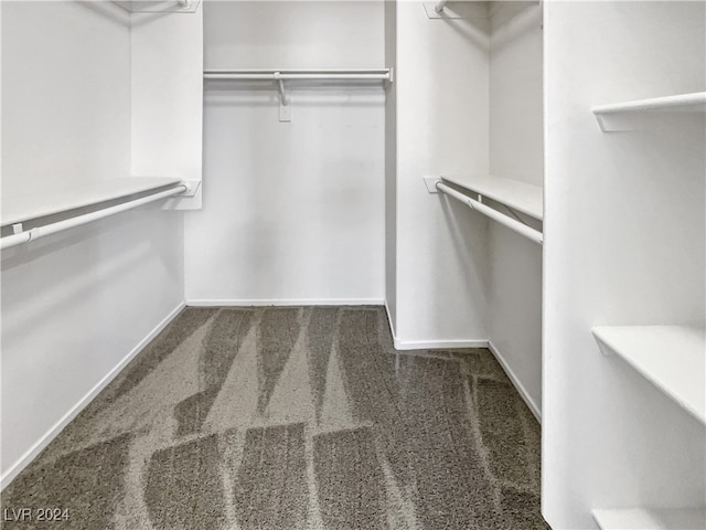 spacious closet with dark carpet