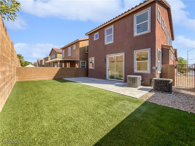 back of property with a patio, a lawn, and central AC unit