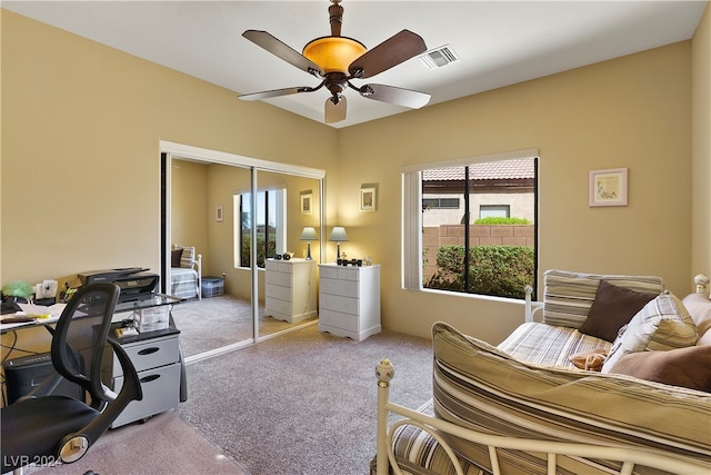 interior space featuring ceiling fan, light colored carpet, and a closet