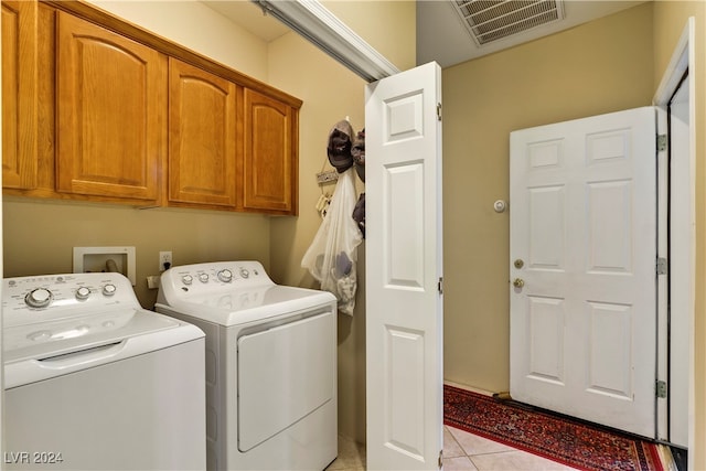 washroom featuring light tile patterned floors, independent washer and dryer, and cabinets