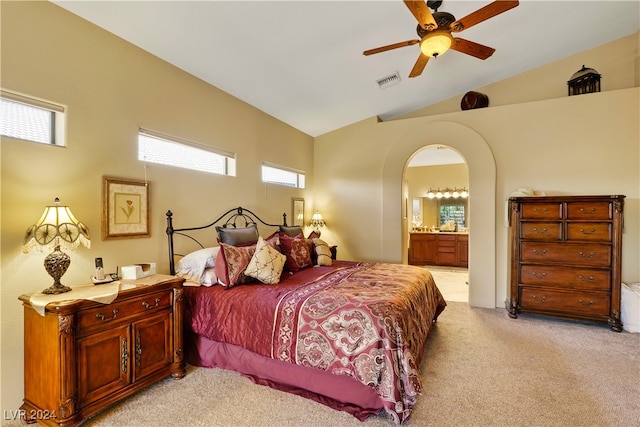 carpeted bedroom featuring connected bathroom, vaulted ceiling, and ceiling fan