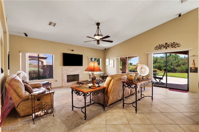 living room featuring ceiling fan, plenty of natural light, light tile patterned floors, and a high end fireplace