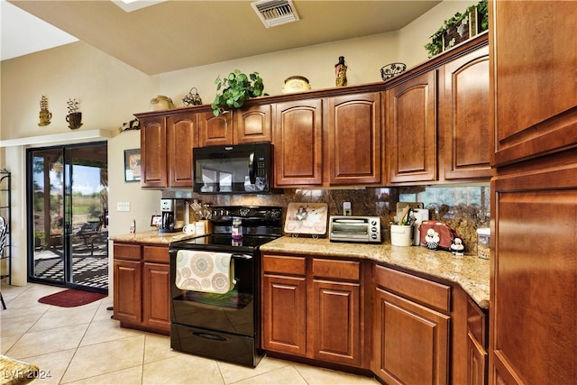 kitchen featuring light stone counters, light tile patterned floors, tasteful backsplash, and black appliances