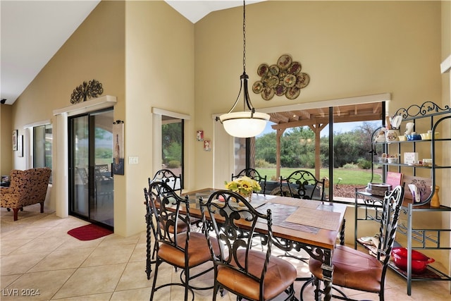 dining space featuring light tile patterned flooring and high vaulted ceiling