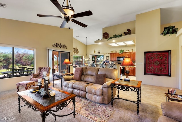 carpeted living room with ceiling fan and high vaulted ceiling