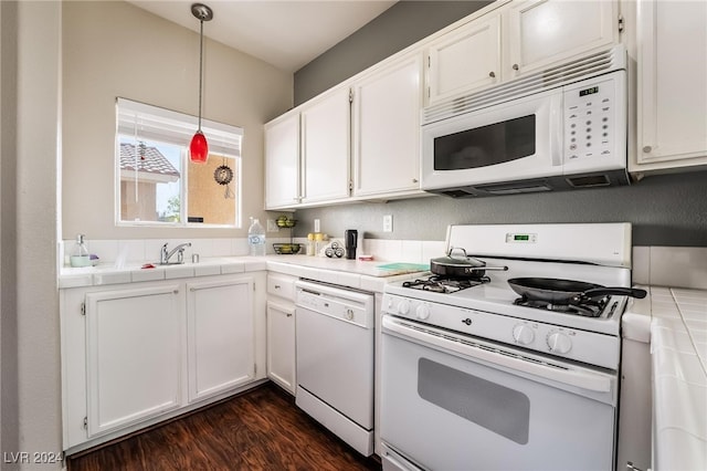 kitchen with tile counters, hanging light fixtures, white appliances, and white cabinets