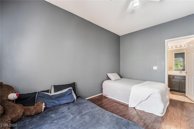 bedroom featuring hardwood / wood-style floors, ensuite bath, sink, ceiling fan, and vaulted ceiling