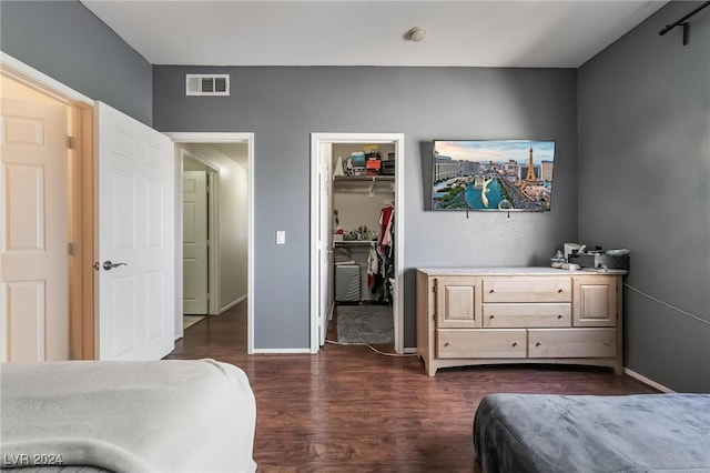 bedroom with a closet, dark hardwood / wood-style floors, and a spacious closet