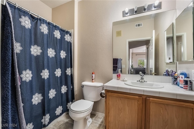 bathroom featuring tile patterned floors, toilet, and vanity