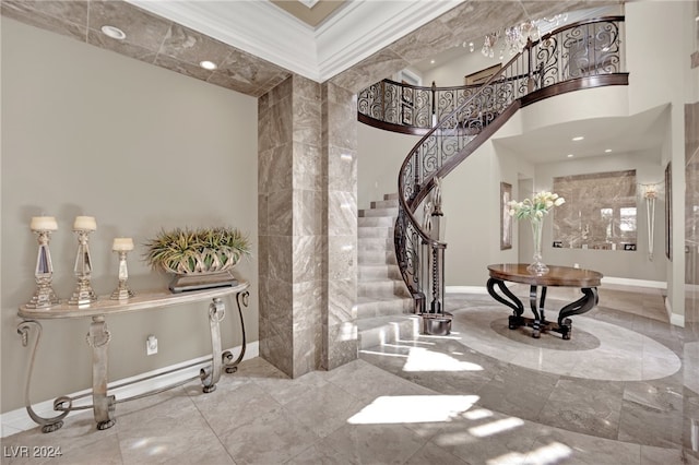 entrance foyer featuring a towering ceiling and ornamental molding