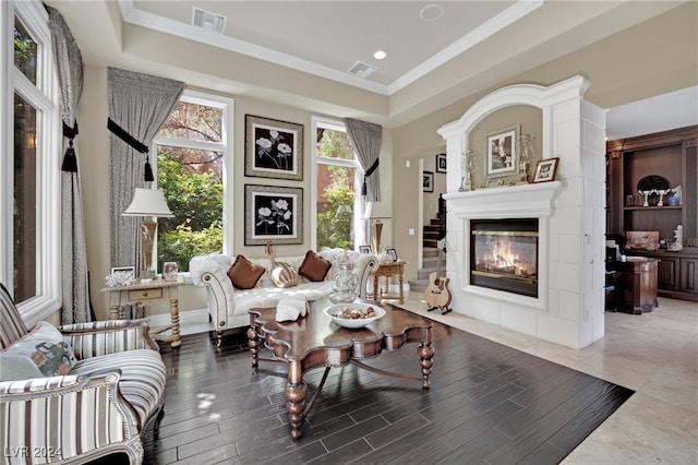 sitting room featuring a raised ceiling, hardwood / wood-style floors, and crown molding