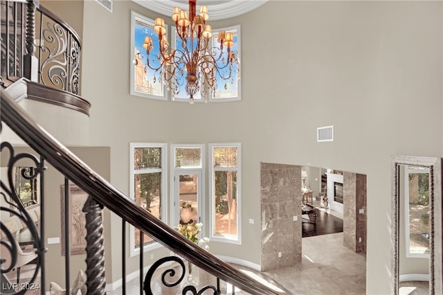 interior space featuring ornamental molding, a premium fireplace, and a notable chandelier