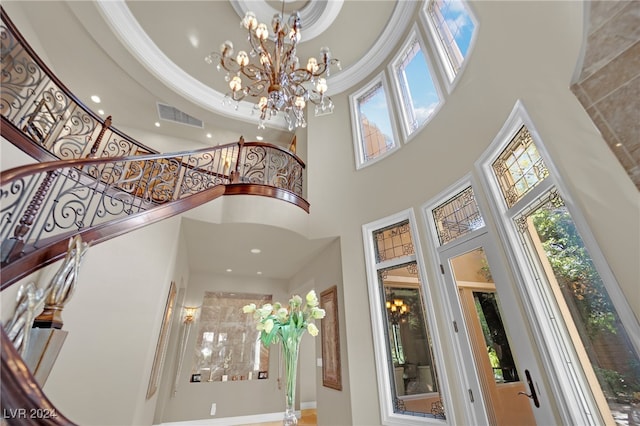 interior space featuring ornamental molding, a tray ceiling, and a notable chandelier