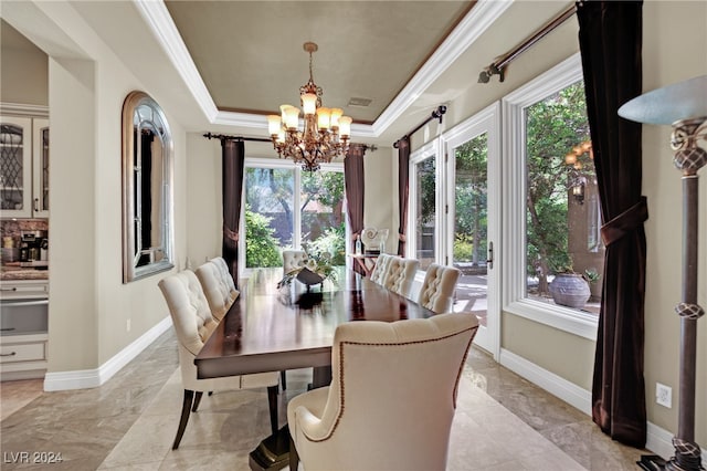 dining room with ornamental molding, a tray ceiling, and a notable chandelier