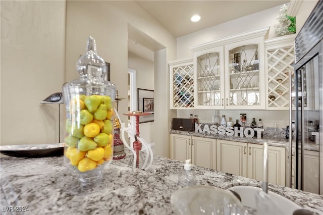 interior space featuring light stone counters and cream cabinets