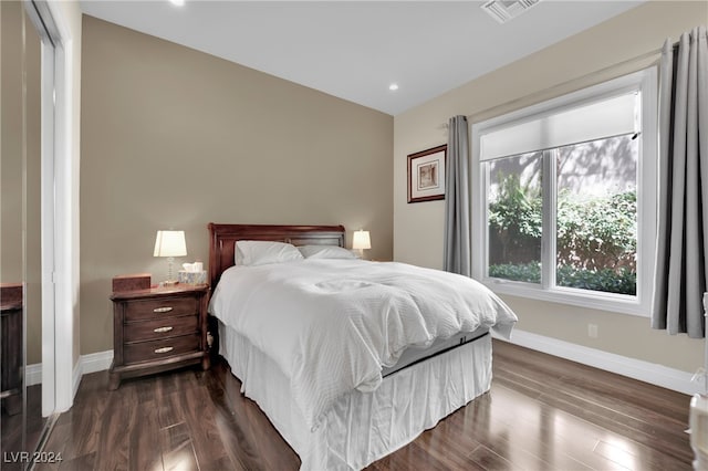 bedroom with dark hardwood / wood-style flooring