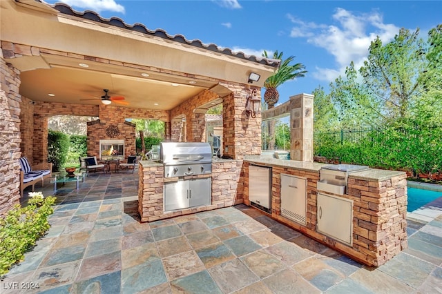 view of patio / terrace featuring ceiling fan, an outdoor kitchen, and a grill