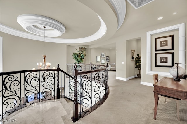 stairway with an inviting chandelier, a raised ceiling, and ornamental molding